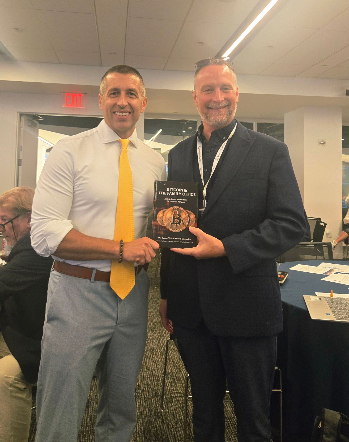 Eric Runge with Richard Wilson at a Family Office Club event, holding a copy of Bitcoin and the Family Office